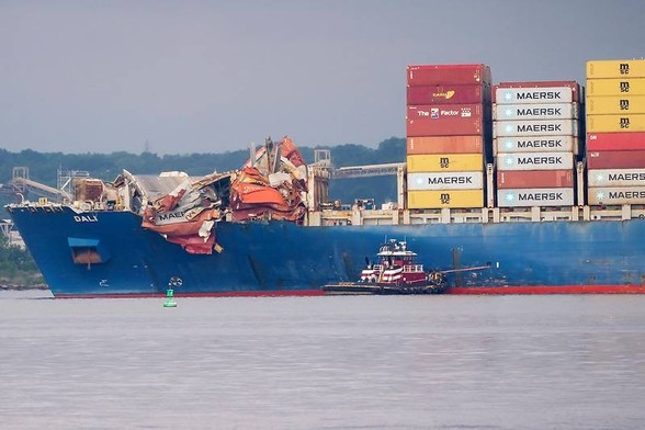 Bild der Front des Frachters, der die Brücke in Baltimore zum Einstürzen brachte, von der Seite.
Man sieht im rechten Teil Containertürme, im linken Teil des Bildes hängen Container-Haufen über die Reling, die so aussehen, als wären sie geschmolzen.
Fotocredits: Reuters/Nathan Howard
Von orf.at 