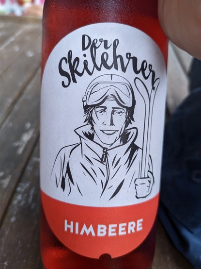 Flaschenetikett mit einem skizzierten Skilehrer, seiner steht 