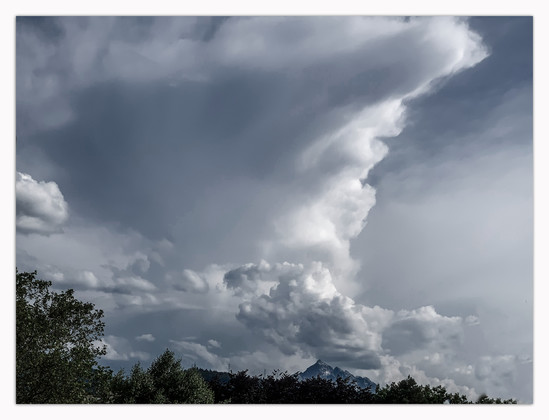 Sich aufbauende Gewitterwolken oberhalb der Serles (Berg im Südwesten von Innsbruck). 
Die Stimmung ist bedrohlich, da die Wolken recht grau sind.